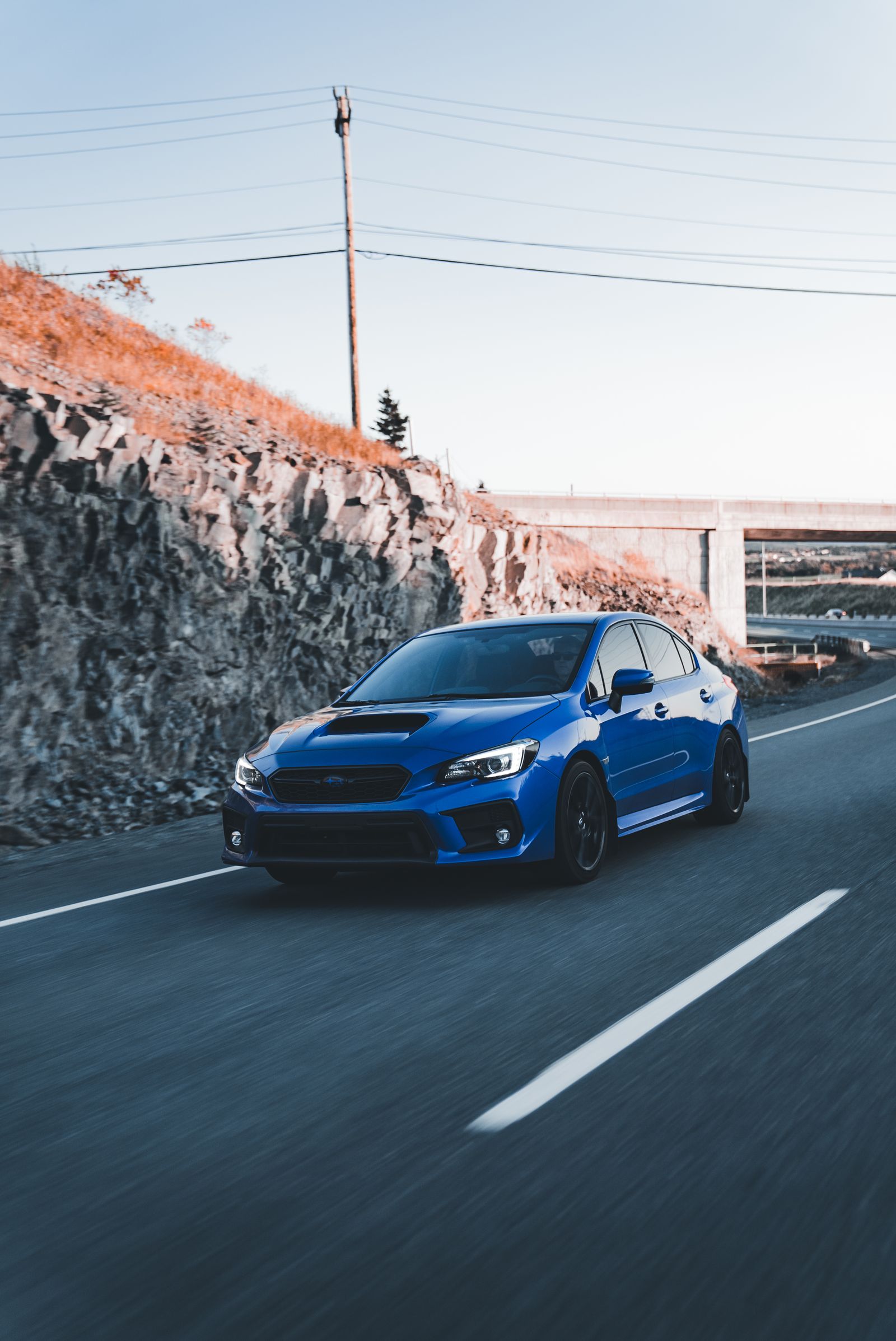 Blue sedan traveling along a scenic road